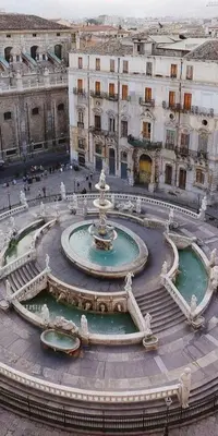 a fountain in the middle of a city with buildings at Hostel Centro Città Basement in Palermo