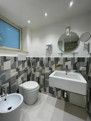 a bathroom with a sink and a toilet and a mirror at Hostel Centro Città Basement in Palermo