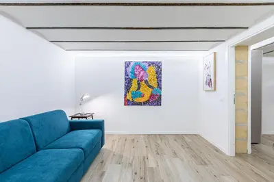 a living room with a blue couch and a painting on the wall at GuestHost - Palermo Modern and Central Apartment x6 in Palermo