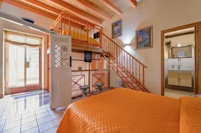 a bedroom with an orange bed and a staircase at CASA ARANCIO in Palermo