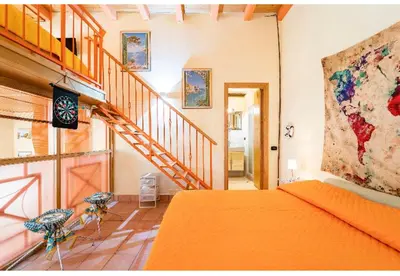 a bedroom with an orange bed and a staircase at CASA ARANCIO in Palermo