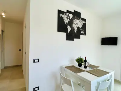 a white dining room with a white table and white chairs at Meravigghia in Terrasini