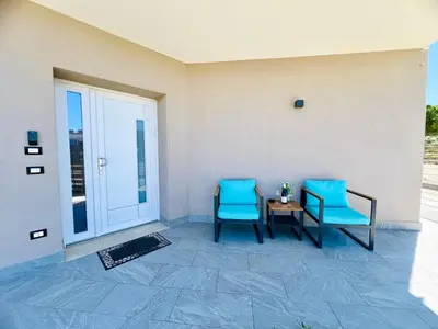 two blue chairs and a table on a patio at Meravigghia in Terrasini
