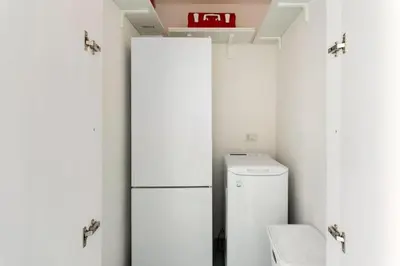 a small kitchen with a refrigerator and a toilet at Casa Mare me' in Mondello
