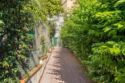 a walkway in a garden with bushes and trees at Casa Mare me' in Mondello