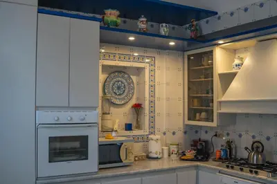 a kitchen with white cabinets and a stove top oven at Materesa in Palermo
