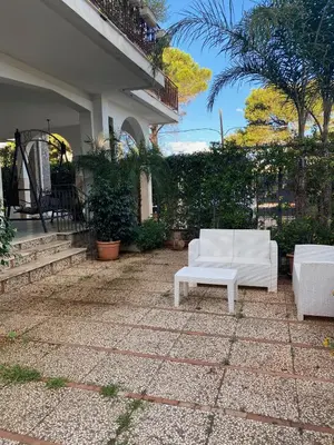 a patio with two white couches on a house at Holiday & House - Imparato Carini Costa Verde - Appartamento con giardino privato - porzione di Villa residenziale a pochi passi dal mare in Carini