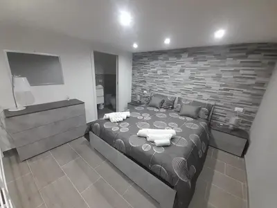 a bedroom with a large bed and a brick wall at House Under Arch in Palermo