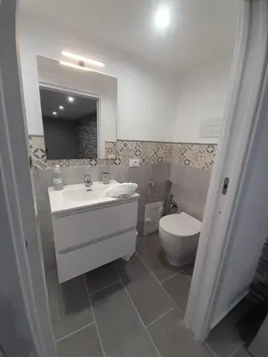 a bathroom with a white sink and a toilet at House Under Arch in Palermo