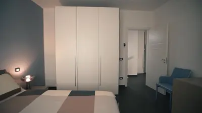 a bedroom with a bed and a cabinet and a blue chair at Mi Tierra Luxury Apartments in Palermo