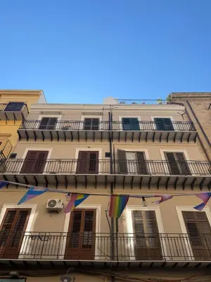 a building with a balcony with a rainbow flag at I Quattru Vuci Rooms in Palermo