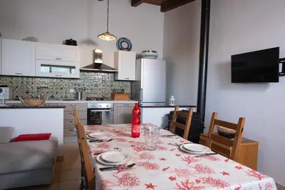 a kitchen with a table with a table cloth on it at Villa Premiere immersa nel verde a Castelluzzo in Castelluzzo