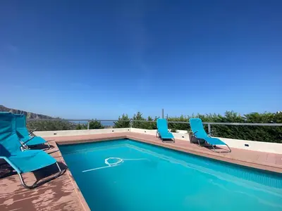 a swimming pool with blue chairs and a swimming pool at Villa Eirene in Termini Imerese