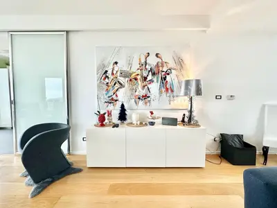 a living room with a white cabinet and a painting on the wall at Villa Eirene in Termini Imerese
