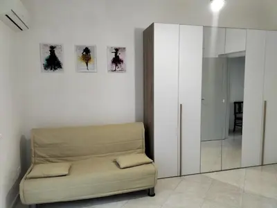 a living room with a chair and a mirror at InCentro Palermo in Palermo