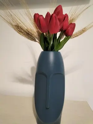 a blue vase with red tulips in it at InCentro Palermo in Palermo