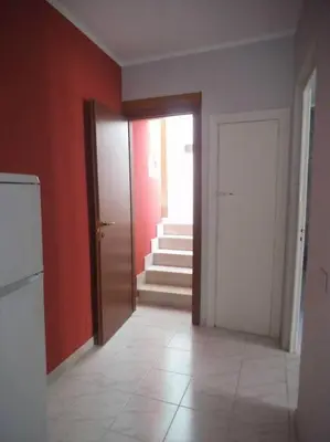 an empty room with red walls and a door and stairs at Bilocale Piano Base Climatizzata in Castellammare del Golfo
