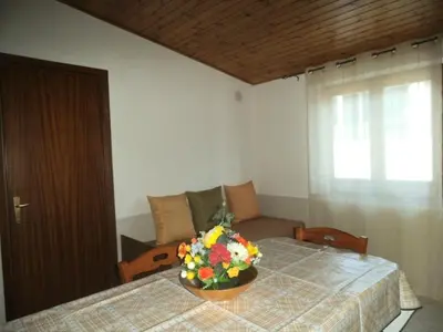 a room with a table with a bowl of flowers on it at Mansarda M&M SX Climatizzata in Castellammare del Golfo