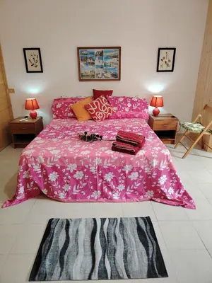 a bedroom with a pink bed with a pink comforter at Casa Derna 25dx Climatizzata in Castellammare del Golfo