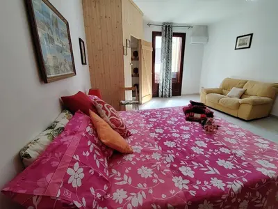 a bedroom with a large bed with a pink blanket at Casa Derna 25dx Climatizzata in Castellammare del Golfo