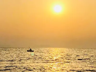 a person in a boat in the ocean at sunset at Villa Portofino - Private pool in Campofelice di Roccella