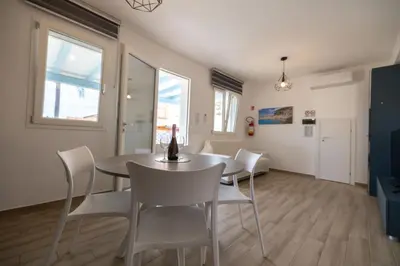 a dining room with a table and white chairs at Villa Portofino - Private pool in Campofelice di Roccella