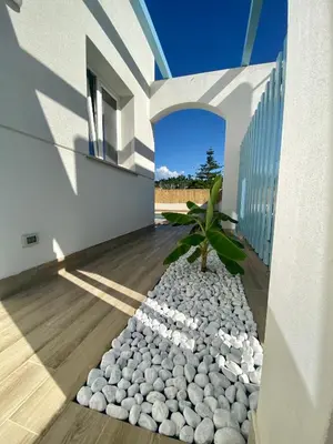 a courtyard of a house with a rock garden at Villa Portofino - Private pool in Campofelice di Roccella