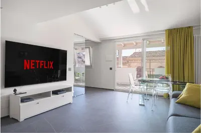 a living room with a television and a table with chairs at Archimedes luxury apartment with terrace in Palermo