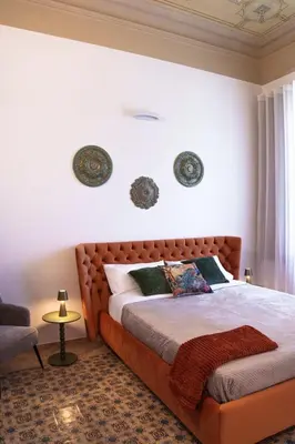 a bedroom with a large bed with a brown headboard at Doma in Palermo