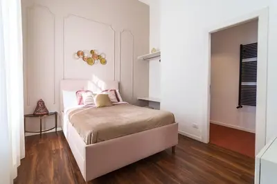 a bedroom with a bed with pink pillows on it at Doma in Palermo
