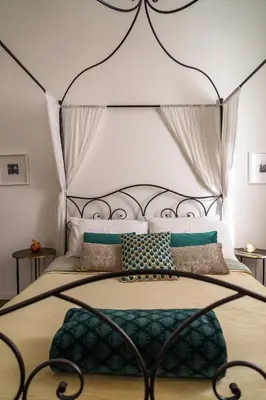 a bedroom with a large bed with a metal headboard at Doma in Palermo