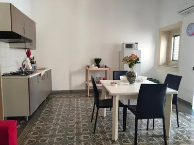 a kitchen with a table and chairs in a kitchen at Casa Lia al centro di palermo in Palermo
