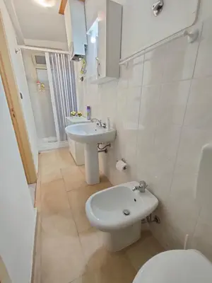 a white bathroom with a toilet and a sink at Casa Lia al centro di palermo in Palermo