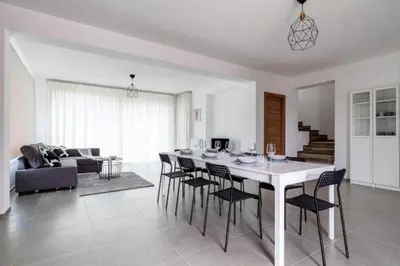 a dining room and living room with a table and chairs at Villa Sikania Seaview Scopello in Castellammare del Golfo