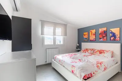 a white bedroom with a bed and a kitchen at Villa Sikania Seaview Scopello in Castellammare del Golfo
