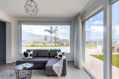 a living room with a couch and a large window at Villa Sikania Seaview Scopello in Castellammare del Golfo