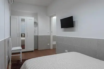 a bedroom with a bed and a tv on the wall at OLIVUZZA TOWER in Palermo