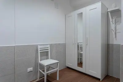a stool in the corner of a room with a mirror at OLIVUZZA TOWER in Palermo