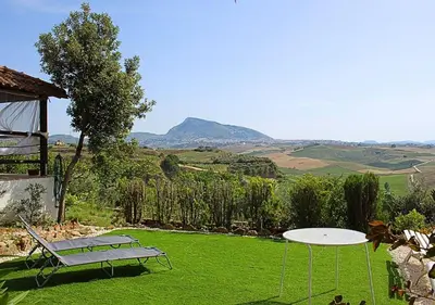 a table and a bench on a field of grass at Villa Finestra sul Castello in Partinico