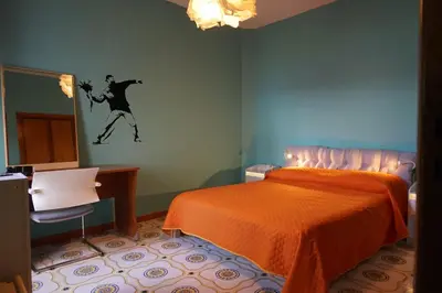a bedroom with a orange bed and a mirror at villa banksy in Palermo