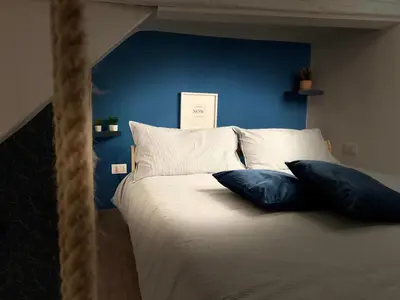 a bed with two pillows and a blue wall at CasaCecè kalsa in Palermo