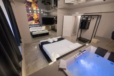 a room with a bed and a bathroom with a tub at Maximum Exclusive Suite & Spa in Palermo