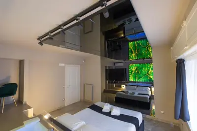 a bedroom with two beds and a large window at Maximum Exclusive Suite & Spa in Palermo