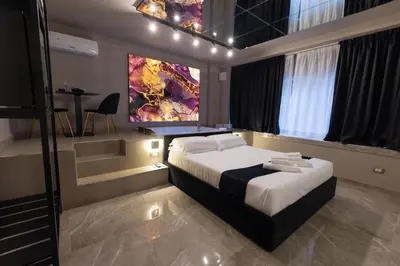 a bedroom with a bed and a painting on the wall at Maximum Exclusive Suite & Spa in Palermo