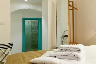 a pile of towels sitting on a bed in front of a mirror at La casa di Chele in Palermo