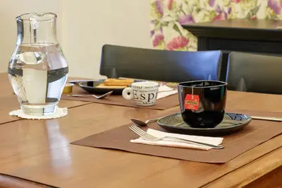 a table with a plate of food and a glass of water at La casa di Chele in Palermo