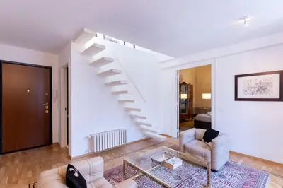 a living room with white walls and a staircase at Appartamento Al Genio in Palermo