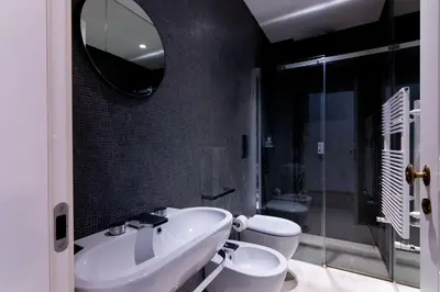 a bathroom with a sink and a toilet and a mirror at Appartamento Al Genio in Palermo