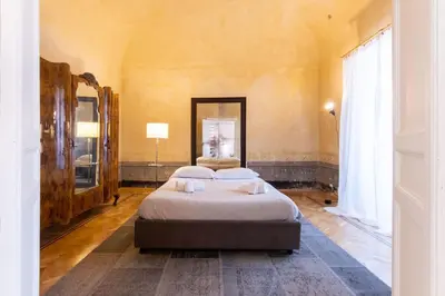a bedroom with two beds and a large mirror at Appartamento Al Genio in Palermo