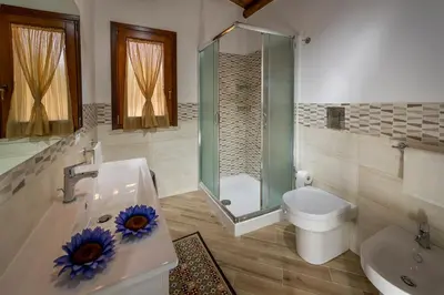 a bathroom with a shower and a toilet and a sink at Casetta degli Ulivi Castellammare del Golfo in Scopello